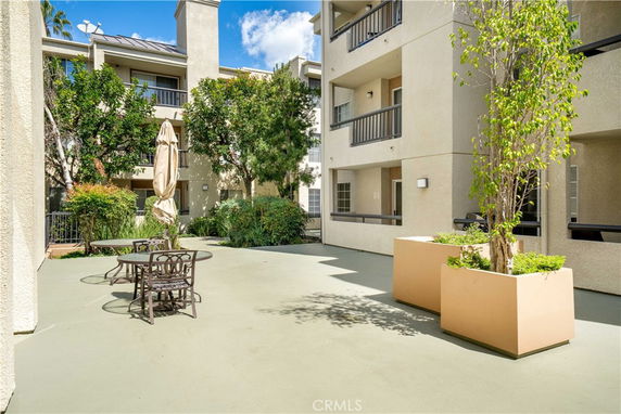 Courtyard view of a multi-story building with balconies and outdoor seating.