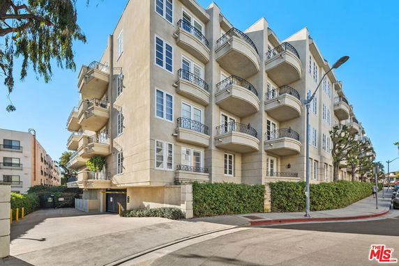 Front view of a multi-story apartment building with balconies.