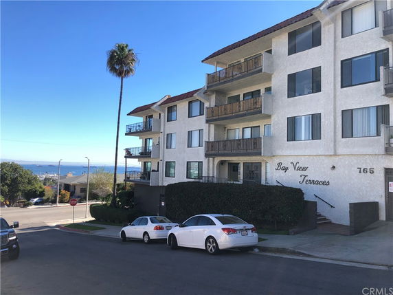 Front view of a multi-story apartment building with balconies.