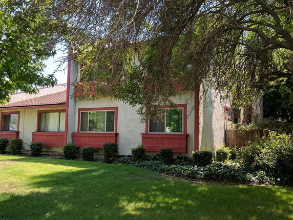 Front view of a two-story house with red window frames.