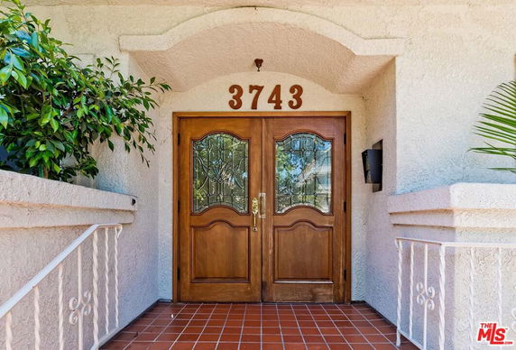 Front view of a building entrance with double wooden doors and house number 3743.