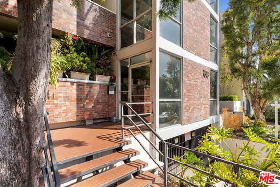 Front view of a multi-story building with brick façade and entry steps.