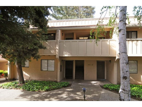 Front view of a two-story house with balconies and a covered entryway.