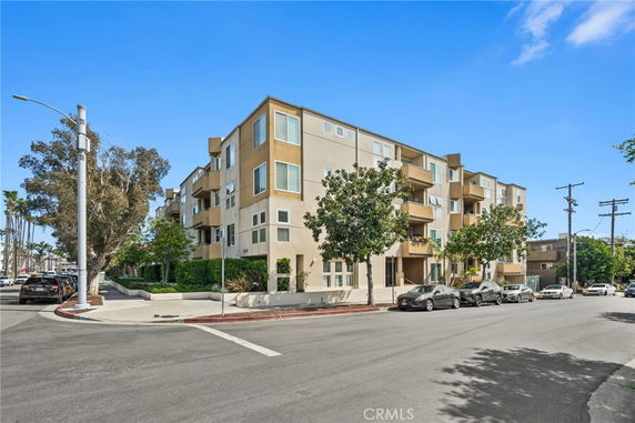 Front view of a multi-story apartment building on a street corner.