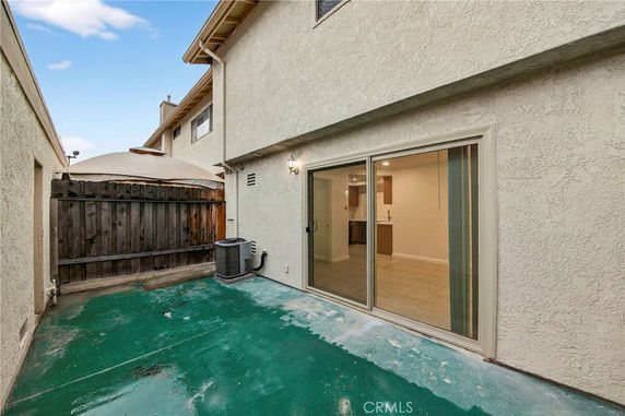 Back view of a multi-story house with sliding glass doors.