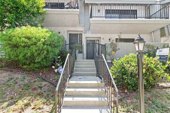 Front view of a two-story building with a staircase leading to the entrance.