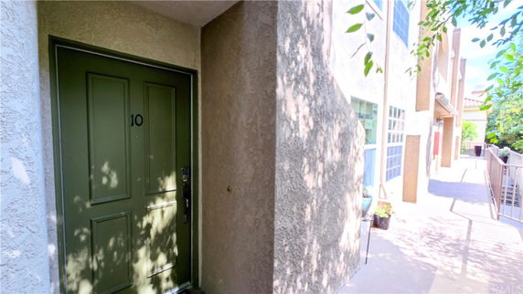 Front view of a building entrance with a green door numbered 10.