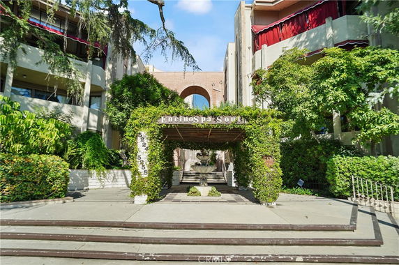 Front view of a building with a green-covered entrance and archway.