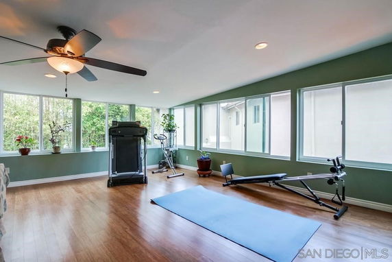 Room with exercise equipment and large windows.