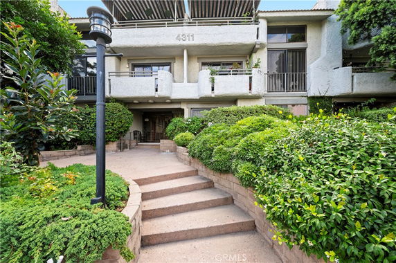Front view of a multi-story building with balconies and entrance.