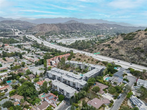 Aerial view of residential area with multi-story buildings and a highway in the background.