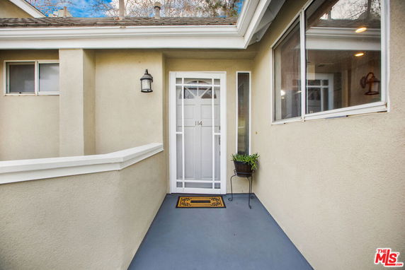 Front view of a house with a small entryway and white door.