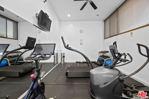 Indoor gym area with exercise equipment, including treadmills and stationary bikes.