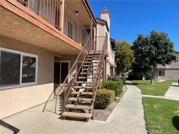 Front view of a two-story residential building with exterior staircases and balconies.