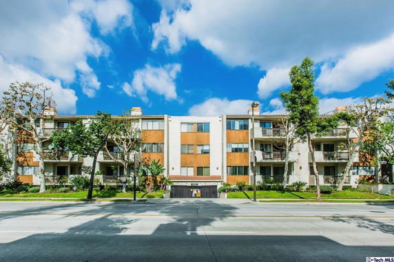 Front view of a multi-story apartment building with balconies.