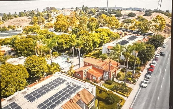 Aerial view of residential area with houses, roads, and greenery.