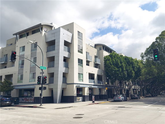 Front view of a multi-story apartment building at an intersection.