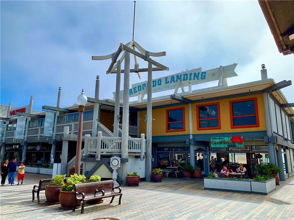 Front view of a building labeled 'Redondo Landing' with an outdoor seating area.