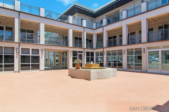 Courtyard view of a multi-story building with large windows and balconies.