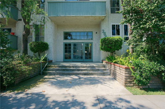 Front view of a multi-story building entrance with steps leading up to double doors.