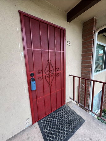Front view of a building entrance with a red metal security door.