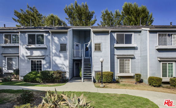 Front view of a two-story residential building with a staircase leading to the upper level.