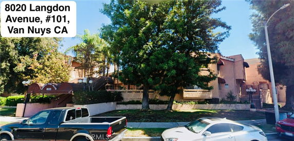 Front view of a multi-story residential building with stairs leading to the entrance.