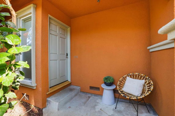 Front entrance of a house with an orange exterior and a white door.