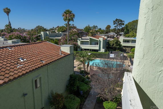 View of a residential area with multiple two-story houses and a central swimming pool.