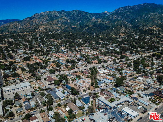 Aerial panoramic view of a residential neighborhood with mountains in the background.