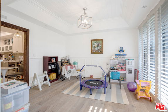 Room with children's play equipment, including a small trampoline and toy storage.