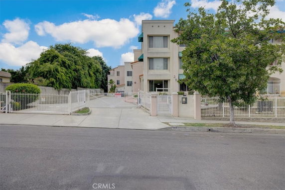 Front view of a multi-story building with gated driveway.