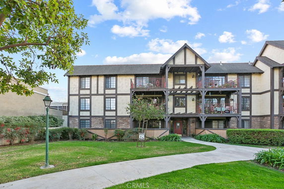 Front view of a multi-story building with balconies and Tudor-style architecture.