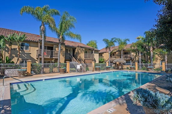 Outdoor swimming pool with adjacent apartment buildings in the background.