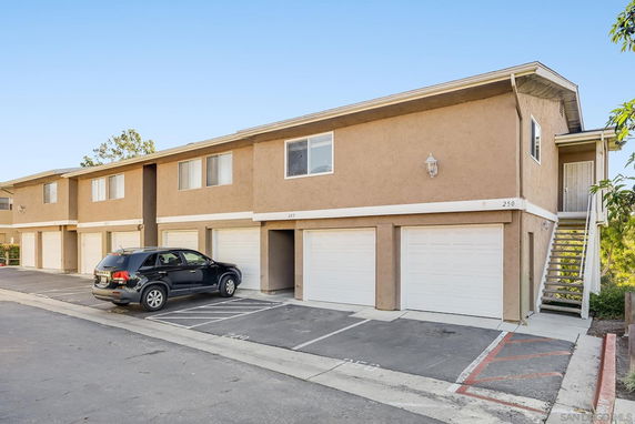 Front view of a two-story apartment building with garages on the ground floor.