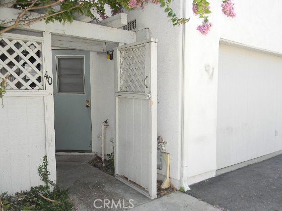 Entrance area of a house with a white wooden gate and a door.