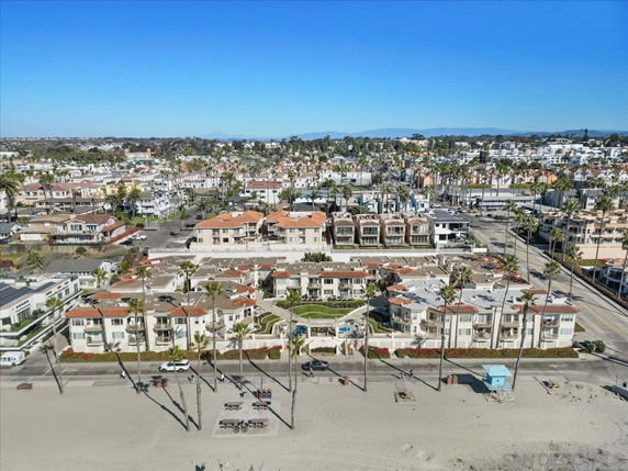 Panoramic view of beachfront properties with a backdrop of a residential area.