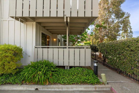Side view of a building with a balcony and wooden paneling.