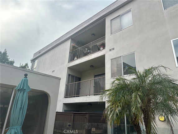 Front view of a multi-story building with balconies and windows.