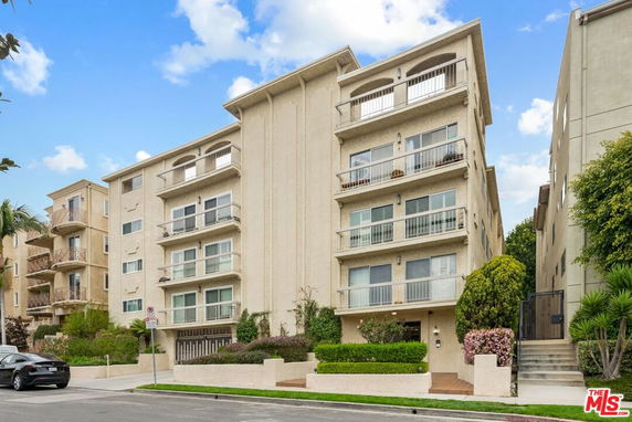 Front view of a multi-story residential building with balconies.