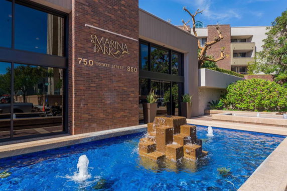 Front view of a building with a brick exterior and a water fountain feature.