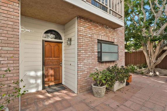 Front view of a house with a wooden door and brick exterior.