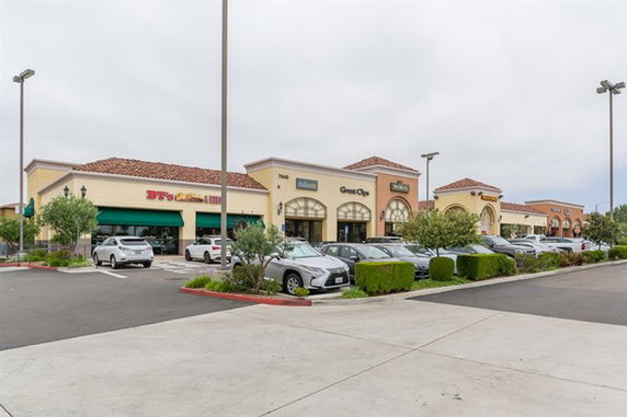 Front view of a commercial shopping center with multiple storefronts.