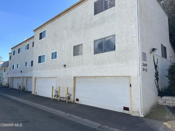 Front view of a multi-story building with multiple garages.