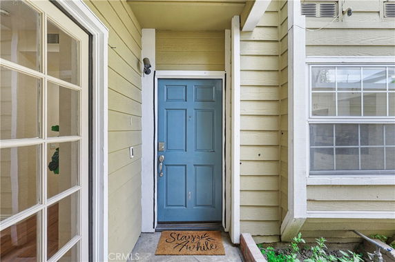 Front view of a house entrance with a blue door and beige siding.