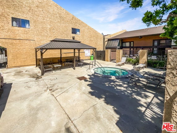Outdoor area with a small circular swimming pool and a shaded seating area.