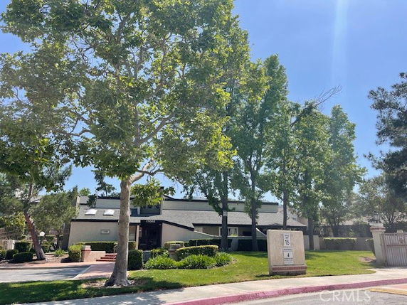Front view of a multi-story house with a well-maintained garden.