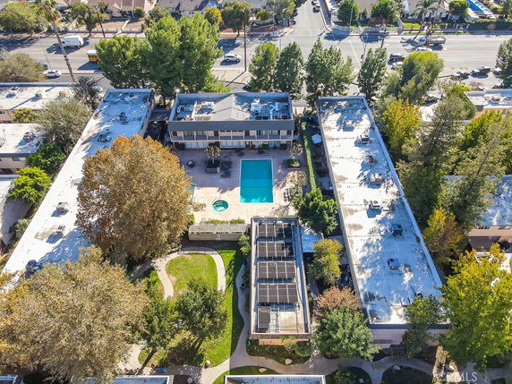 Aerial view of a residential complex with a central swimming pool and surrounding buildings.