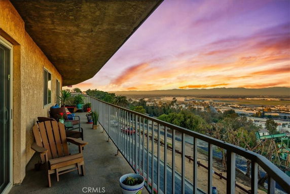 Balcony view overlooking a landscape at sunset.