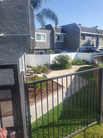 Front view of a multi-story residential building with a gated entrance.
